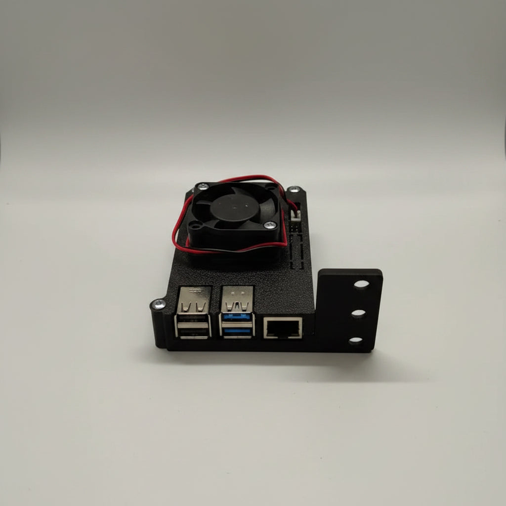 A black 3D-printed electronic enclosure with two USB 3.0 ports, an RJ45 Ethernet port, and a small black cooling fan with red wires on top, shown on a light surface.